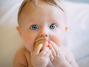 A baby being gently held, symbolizing infant and family support.